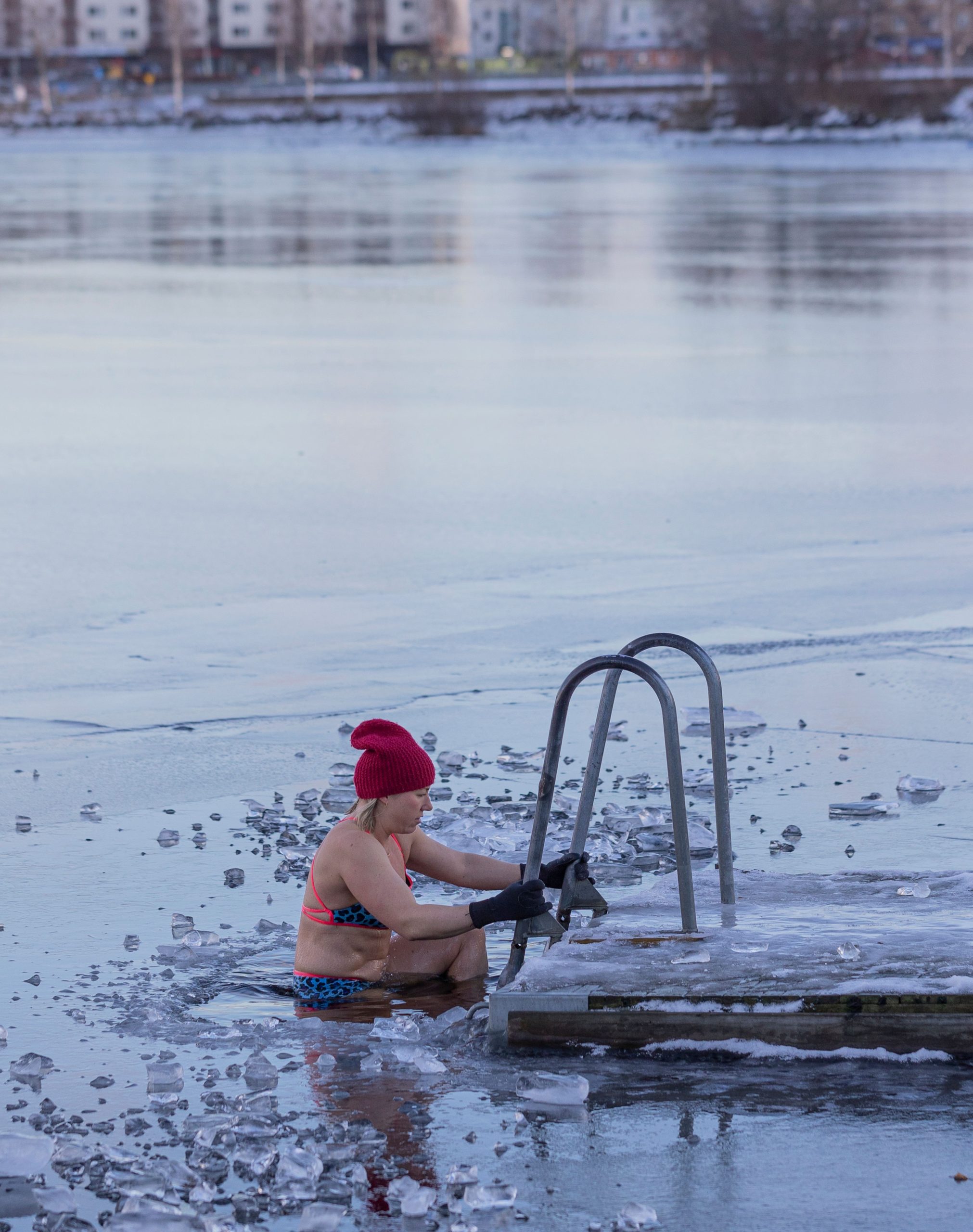 Woman doing a cold water plunge outdoors in winter